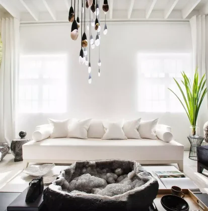 Salón con un sofá blanco, una planta alta y un cuarzo como centro de mesa.